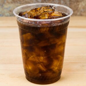 1113347 : Elementa Inc Compostable PLA Cold Cup Filled with Soda and Ice on a wooden table.